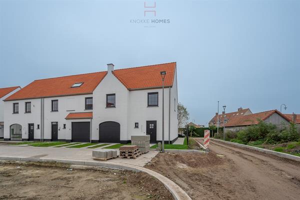 Maison neuve à 3 façades avec garage et jardin.